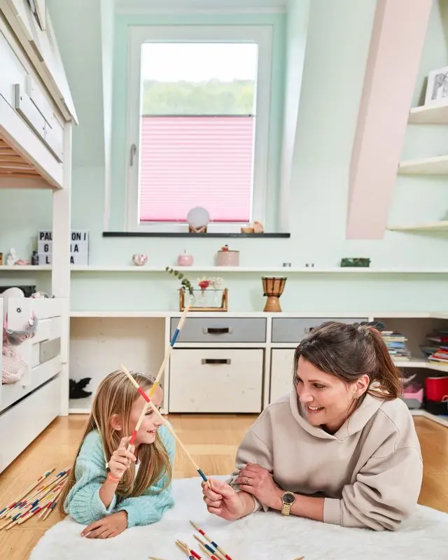 Plissees für das Kinderzimmer in blickdichten Rosa in einem Fenster