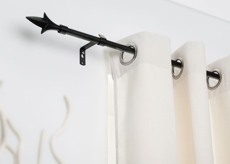 Gardinenstange in schwarzen Edelstahl mit Bohrung angebracht an eine weiße Wand mit weißer Gardine und Pfeilabschluss Gardinenstange in schwarzen Edelstahl mit Bohrung angebracht an eine weiße Wand mit weißer Gardine und Pfeilabschluss