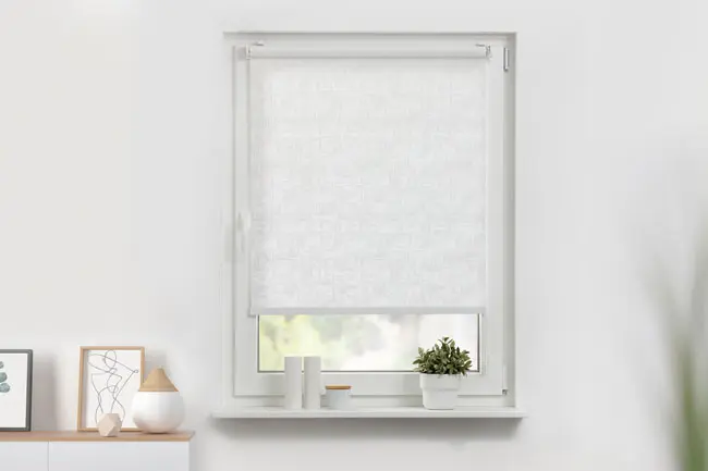 Blickdichtes Rollo in weiß angebracht in einem Fenster