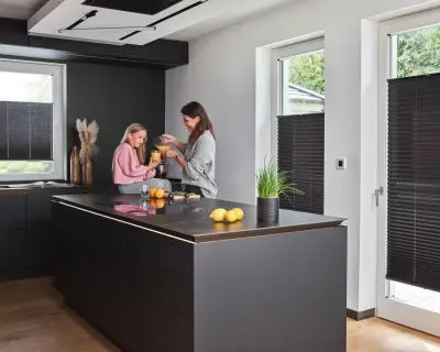 Blickdichte Plissees in schwarz für Fenster und bodentiefe Fenster in einer Küche