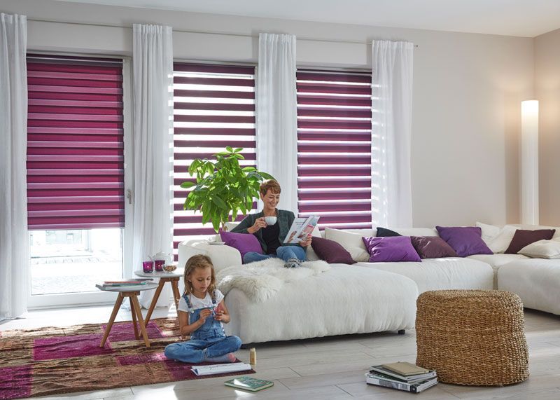 Doppelrollo für das Wohnzimmer in Rosa und Lila als blickdichter Sichtschutz angebracht in bodentiefen Fenstern Doppelrollo für das Wohnzimmer in Rosa und Lila als blickdichter Sichtschutz angebracht in bodentiefen Fenstern