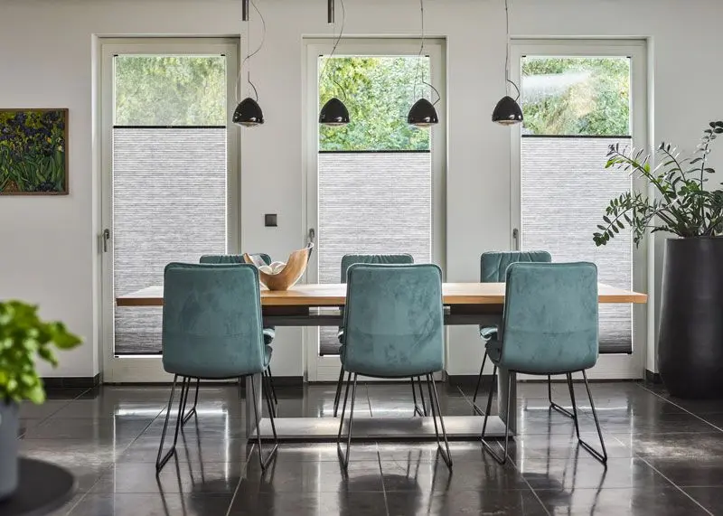 Wabenplissees in grau und schwarz in einem Esszimmer in Balkontüren geklemmt